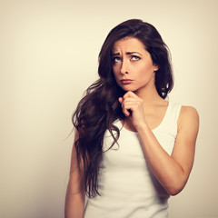 Confusion very offended brunette woman thinking and looking up. Toned vintage portrait