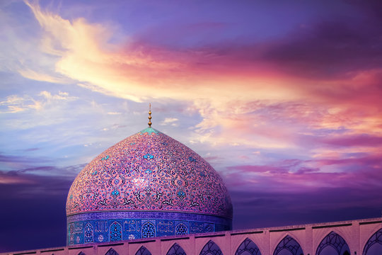 Fragment of traditional Iranian architecture against beatiful purple sky and yellow and pink clouds. Beautiful sunset. Iranian Islamic national image.
