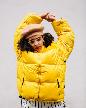 Beautiful mixed ethnicity woman wearing thick yellow puffer jacket