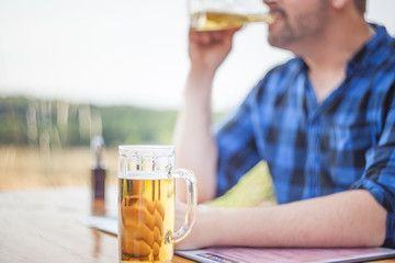 junger Mann am Tisch  trinkt  ein Bier