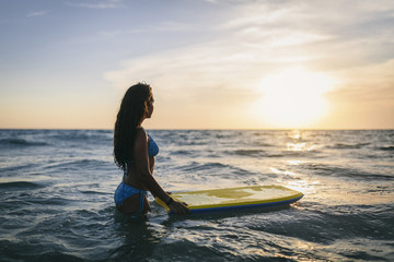 Cute teen girl with a bodyboard at the beach