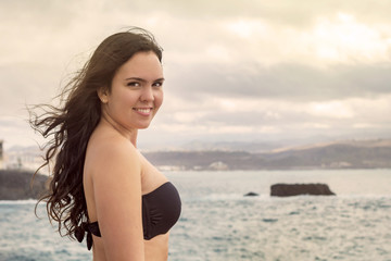 Fototapeta na wymiar Smiling woman in black bikini.