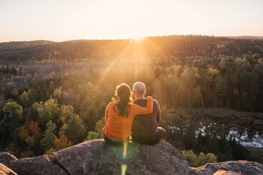 Couple enjoying beautiful sunset view on mountain