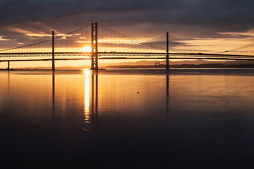Fototapeta na wymiar Two bridges against the setting sun and the sea