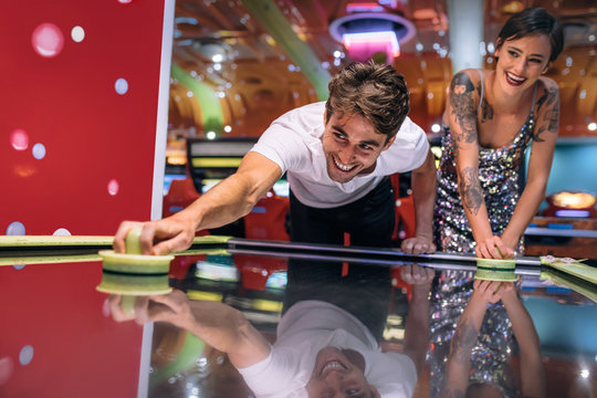 Couple Playing Air Hockey Game At A Gaming Arcade