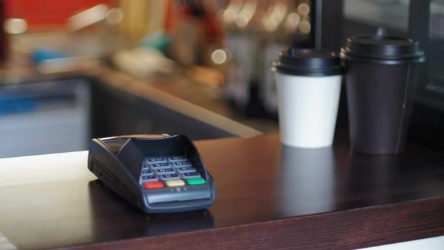 Business woman in cafe is paying the price by using a smart watches and terminal