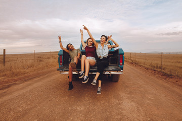 Women enjoying the pickup truck ride - obrazy, fototapety, plakaty