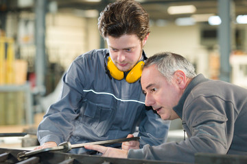 man working with apprentice in printing house