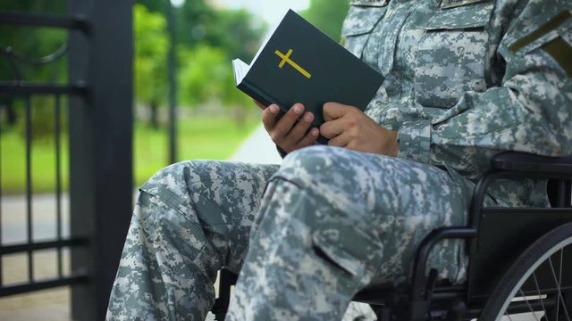 Disabled serviceman in wheelchair reading bible, religious faith health recovery