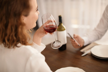 Woman with glass of wine at table in restaurant