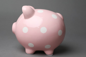 Cute pink piggy bank on gray background