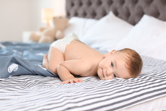 Adorable little baby lying on bed at home