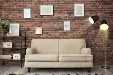 Modern living room interior with comfortable sofa near brick wall