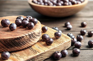 Fresh acai berries on wooden table, closeup