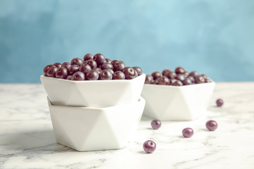 Bowls with fresh acai berries on marble table