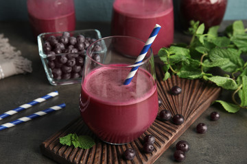 Composition with glass of acai juice and fresh berries on dark table