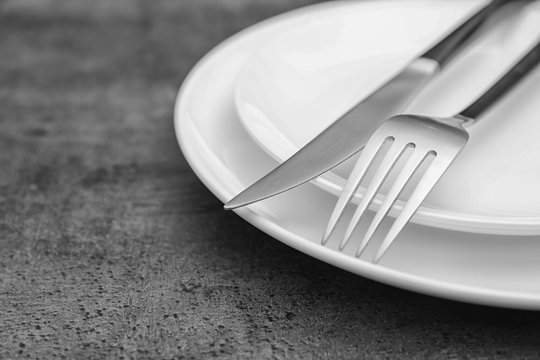 Empty dishware and cutlery on gray background, close up view. Table setting