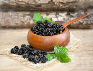 Ripe blackberry in a wooden plate