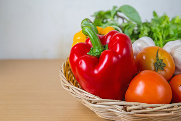 Fototapeta na wymiar Organic vegetables in the wicker basket on wooden background