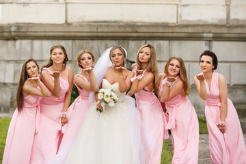 Wedding. Bride and bridesmaids in pink dresses having fun at wedding day. Happy marriage and wedding party concept - obrazy, fototapety, plakaty