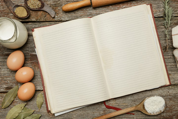 Blank cookbook with some ingredients on the wooden table, top view, rustic style
