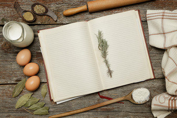 Blank cookbook with some ingredients on the wooden table, top view, rustic style
