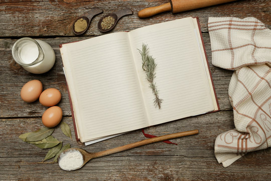 Blank cookbook with some ingredients on the wooden table, top view, rustic style
