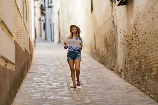 Woman doing tourism with map at Granada, Spain.