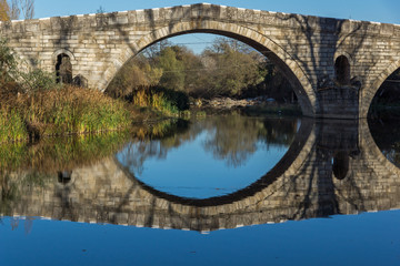 Fototapeta na wymiar Autumn view of Kadin most - a 15th-century stone arch bridge over the Struma River at Nevestino, Kyustendil Province, Bulgaria