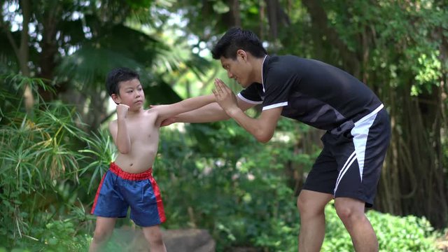 Asian little chinese boy study thai boxing with coacher. concept of sport exercise.