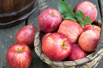 Red Apples and a Basket on a Rustic Wooden Surface