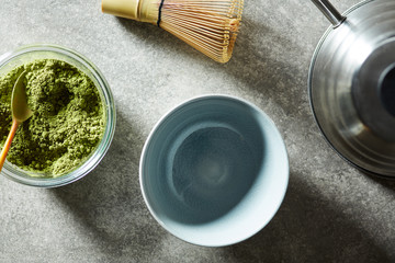 Bowls with green matcha tea and utensils for preparing tea.