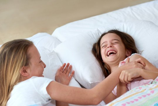 Sisters having fun tickling in bed