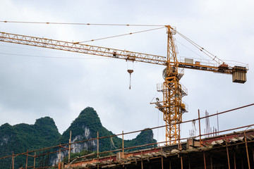 Tower crane on a background karst peak