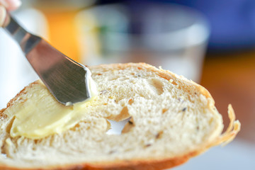 Hands spreading butter on bread