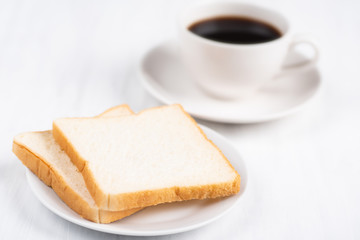 Fototapeta na wymiar Sliced bread and cup of black coffee on white table, breakfast
