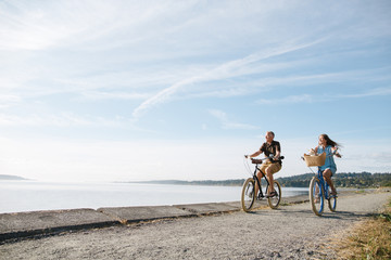 Healthy, active couple enjoying life riding cruiser bikes near o