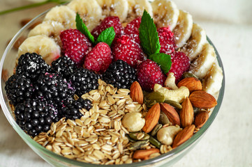 Eating healthy breakfast bowl. Fruit in a plate with a healthy meal. Raspberry, Banana, Nuts. dieting, Vegetarian food concept 