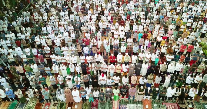 JAKARTA, Indonesia - July 17, 2018: Aerial view of muslim people praying Eid Al Fitr together on the road in Jakarta city. Shot in 4k resolution