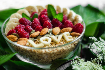 Eating healthy breakfast bowl. The word LOVE in a plate with a healthy meal. Raspberry, Banana, Nuts. Vegetarian food concept