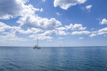 Katamaran und Segelboote auf dem Meer mit blauen Himmel im Sommer 