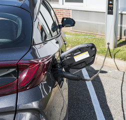 Electric hybrid car plugged in at charging station