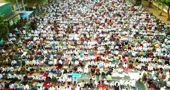 JAKARTA, Indonesia - July 17, 2018: Aerial shot of muslim people praying together outdoors in Eid Al Fitr day. Shot in 4k resolution