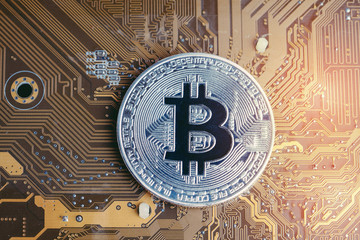 Fototapeta na wymiar Crypto currency Bitcoin digital money concept, shiny golden physical bitcoin coin on technology and electronics look circuit board with artificial light
