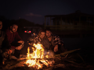 Obraz premium Couple enjoying with friends at night on the beach