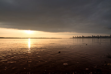 Naklejka premium water pollution in a river with a city view on the horizon during the sunset