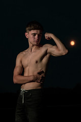 Fototapeta na wymiar Young adult male posing shirtless at sunset