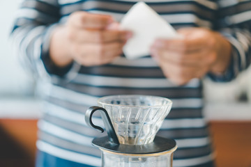 barista prepare filter paper on dripper to brew coffee