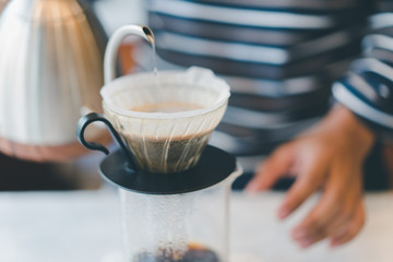 Fototapeta na wymiar barista pour hot water into dripper to brew coffee