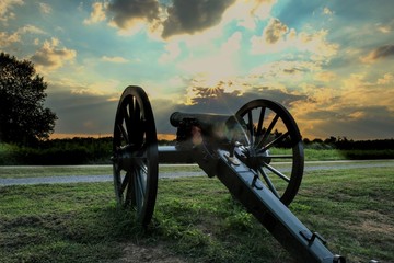 an old Civil War cannon points towards the sunset at Stones River National Battlefield in...